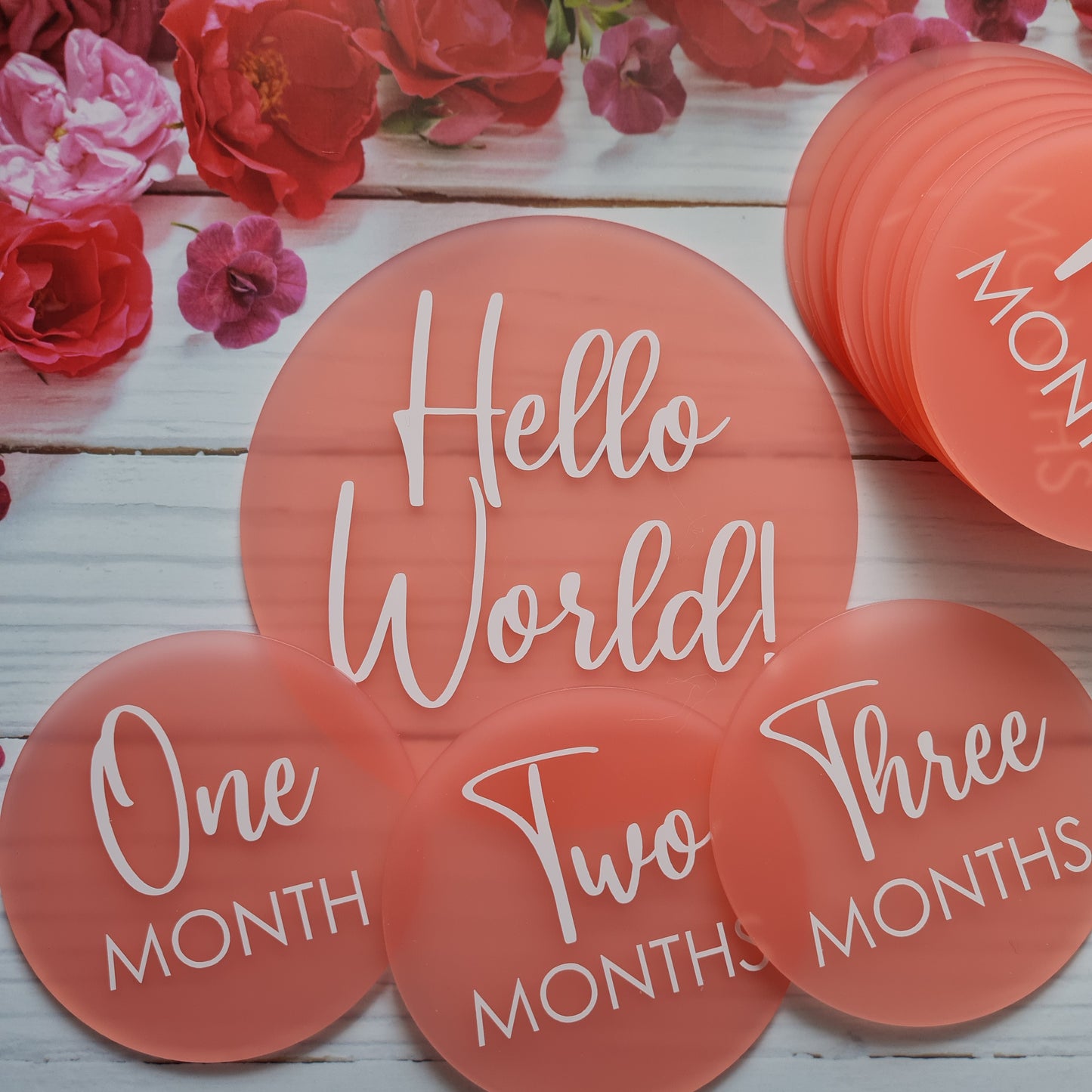 Baby milestone discs in blush acrylic with white lettering